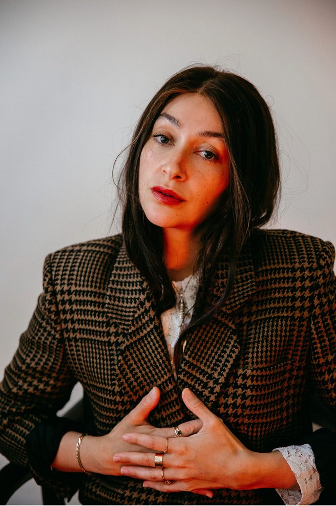 Editorial portrait of Tova Sherr in a checked blazer
